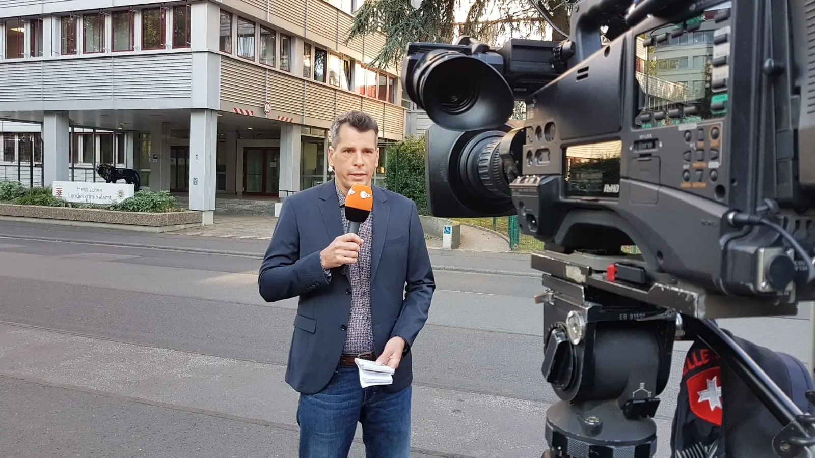 Journalist mit Mikrofon bereitet sich auf eine Live-Reportage vor